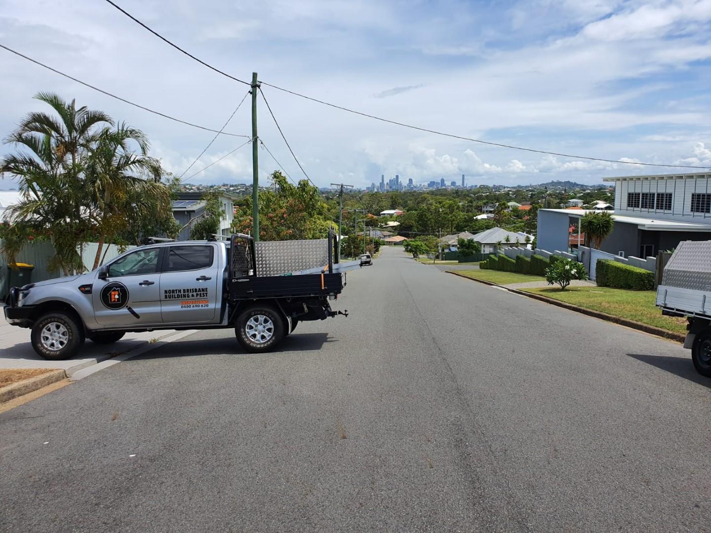 Brett's Building inspection Ute on the driveway of a building inspection house with views of Brisbane CBD in the background